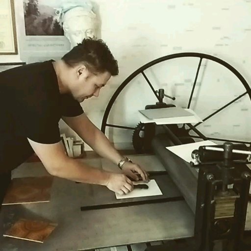 Дмитрий Крель за работой на офортном станке, на котором печатаются линогравюры